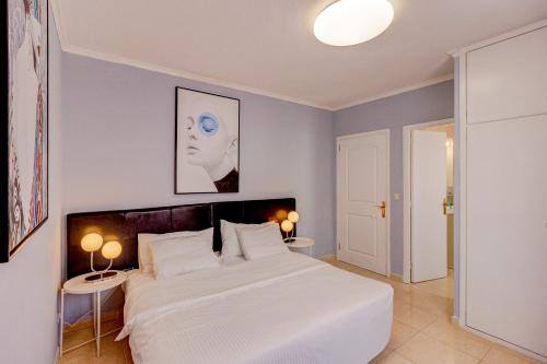 a bedroom with a large white bed and two tables at Ocean View 3bedroom Villa with pool in Callao Salvaje