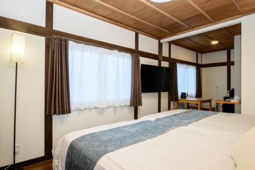 a bedroom with a large bed and a television at 66 Lodge Country Station in Kimobetsu