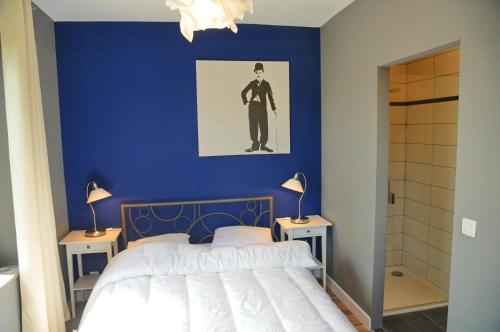 een blauwe slaapkamer met een bed en twee nachtkastjes bij Gîte Miss Chloé in Barvaux
