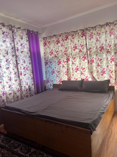 a bedroom with a bed with flowers on the walls at Bittu Homestay in Kaza