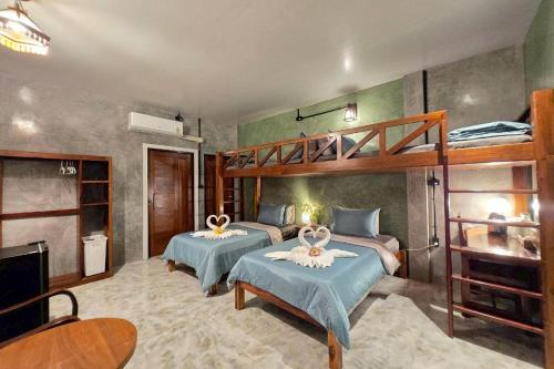 a bedroom with two beds and a bunk bed at Smilingface guesthouse in Sukhothai
