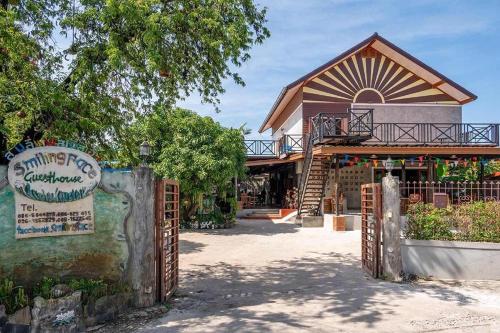 a gate in front of a building with a sign at Smilingface guesthouse in Sukhothai