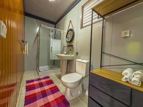 a bathroom with a toilet and a shower and a sink at Tekehani Lodge in Araito