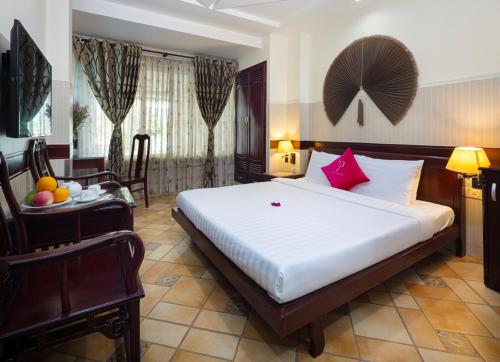 a hotel room with a bed and a table and chairs at Pink Horizon Saigon Airport Hotel in Ho Chi Minh City
