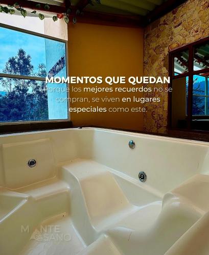 a white bath tub in a room with a window at MONTESANO Finca HOTEL in Jenesano