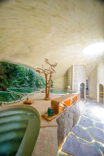 a house with a swimming pool with a tree in it at Ulaman Eco Luxury Resort in Tabanan