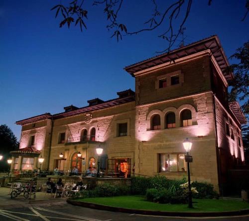 a building with people sitting outside of it at night at Hotel Artaza in Getxo