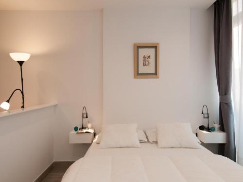 1 dormitorio blanco con 1 cama y 2 mesitas de noche en Apartments Las Canteras Beach LM3, en Las Palmas de Gran Canaria