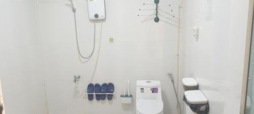 a white bathroom with a toilet and a phone at water fall resort soksan in Phumĭ Kaôh Rŏng