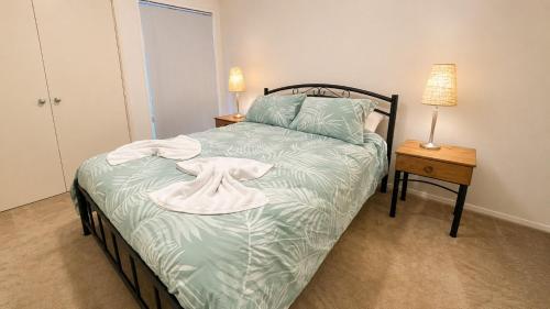 a bedroom with a bed with a white robe on it at Beachside on Kent in Busselton