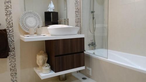 a bathroom with a sink and a shower and a tub at casa do lago in Monchique