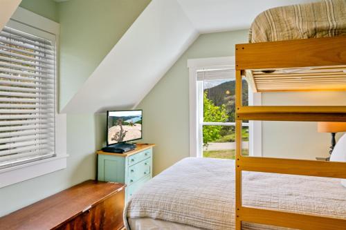 a bedroom with a bunk bed and a television at Acadia View Cottage Peaceful, Pet Friendly, Fire Pit, Near Peaks and Echo Lake in Hall Quarry