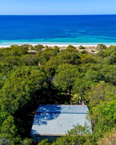 an overhead view of a building in the trees with the beach at Edgewater on Quindalup Beachfront in Quindalup