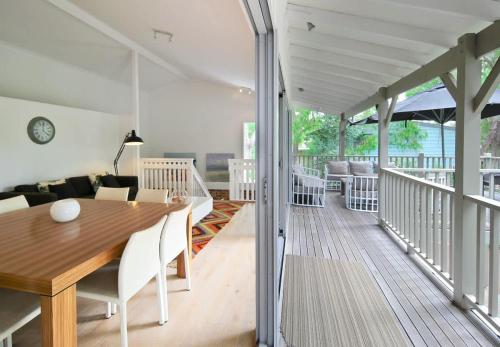 a dining room and living room with a wooden table at Edgewater on Quindalup Beachfront in Quindalup