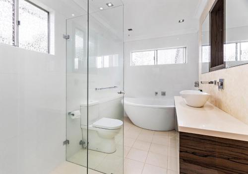 a bathroom with a tub and a toilet and a sink at Tabone on Jones in Kiama Downs