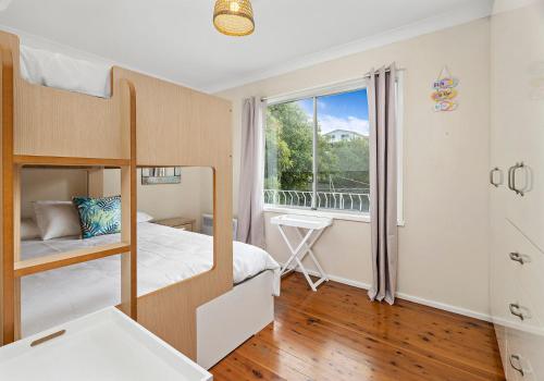 a bedroom with a bunk bed and a window at Tabone on Jones in Kiama Downs