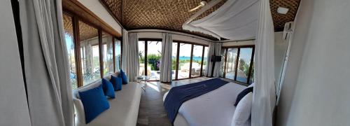 sypialnia z łóżkiem z niebieskimi poduszkami i oknami w obiekcie JHotelResorts w mieście Ad-Damur