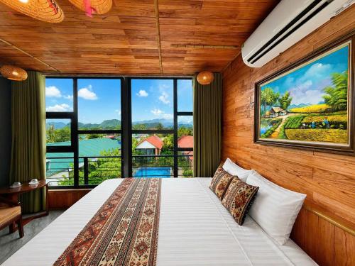 a bedroom with a bed and a large window at Trang An Green Retreat Homestay in Ninh Binh
