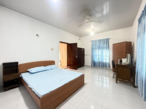 a bedroom with a bed and a desk in it at Garden Cottage Homestay BB in Wattala