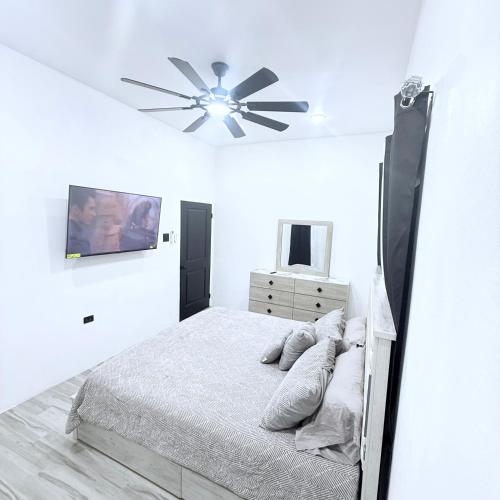a bedroom with a bed and a ceiling fan at Modern Caribbean retreat 2 in Kingston