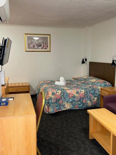 a hotel room with a bed and a desk at Edgecliff Lodge Motel in Sydney