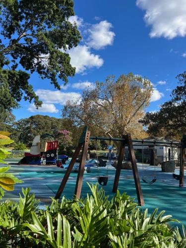 a playground with a swing in a park at Edgecliff Lodge Motel in Sydney