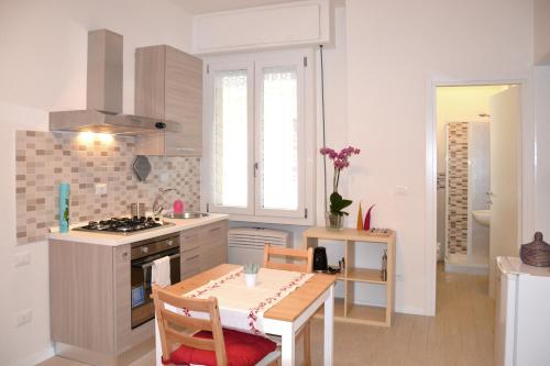 uma cozinha com uma mesa e um fogão forno superior em Appartamenti nonna Dina em Florença