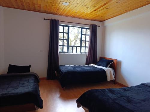 a bedroom with two beds and a window at Hotel Páramo de Sumapaz in San Juan
