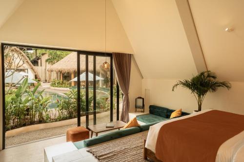 a bedroom with a bed and a large window at Hotel Together Bali in Uluwatu