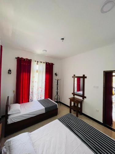 a bedroom with two beds and red curtains at Veenu Homestay in Badulla