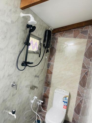 a bathroom with a shower and a toilet in it at Veenu Homestay in Badulla