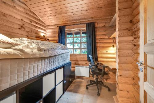 a bedroom with a bed and a desk and a chair at Charming Cabin With Wilderness Hot Tub in Asnæs