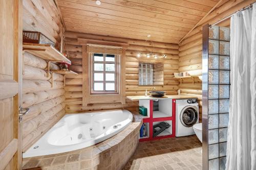 a large tub in a bathroom with wooden walls at Charming Cabin With Wilderness Hot Tub in Asnæs