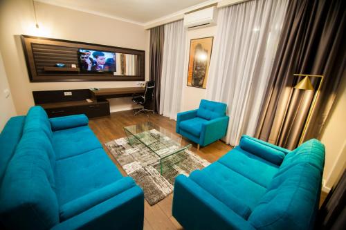 a living room with a blue couch and two blue chairs at Cluj Business Class in Cluj-Napoca