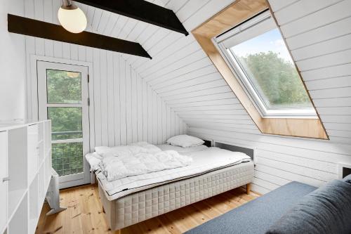 a bed in a white room with a window at Lovely Beach Home Enveloped In Green Surroundings in Ebeltoft
