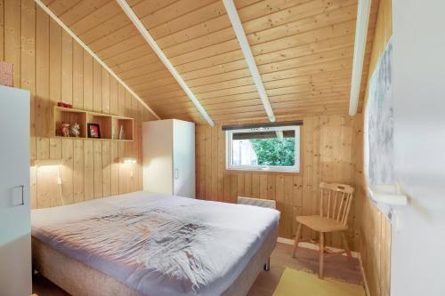ein Schlafzimmer mit einem Bett in einem Holzzimmer in der Unterkunft Schönes Sommerhaus Mit Herrlichem Blick in Ølsted