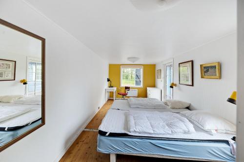 a bedroom with two beds and a mirror at Charming Cottage Near The Beach in Neksø