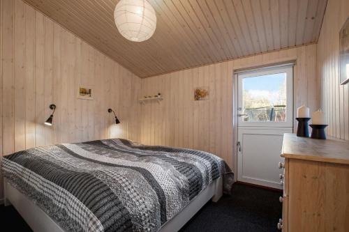 a bedroom with a bed and a window at Cozy Summer House On Scenic Djursland in Glesborg