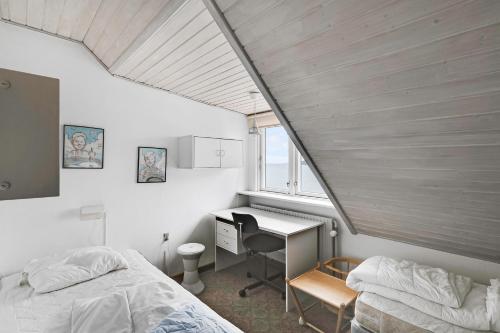 a bedroom with two beds and a desk and a window at Spacious House With Sea Views From All Rooms in Rønne
