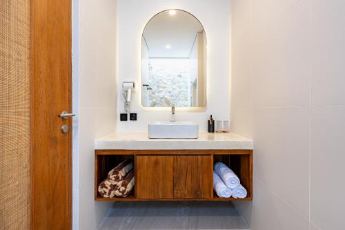 a bathroom with a sink and a mirror at DESAULU VILLAS - Boutique Private Room Pool View in Uluwatu