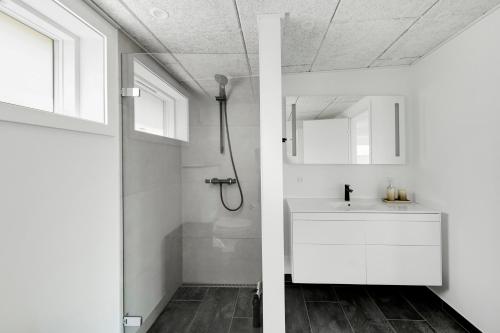 a white bathroom with a sink and a shower at Modern Holiday Home On Adventurous Bornholm in Allinge