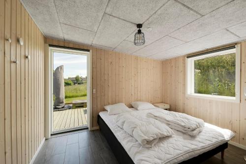 a bedroom with a bed and a large window at Modern Holiday Home On Adventurous Bornholm in Allinge