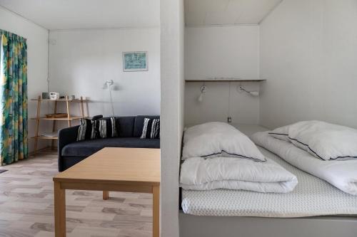 a living room with a bed and a couch at Cozy Holiday Apartment Close To The Beach in Neksø