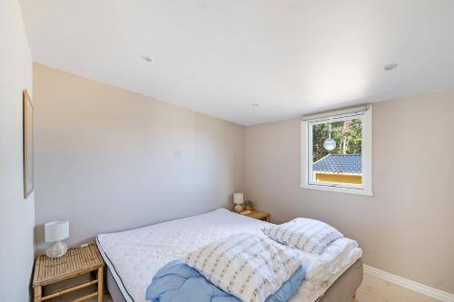 a bedroom with a bed and a window at Beautifully Situated Summer House With Sea View in Allinge