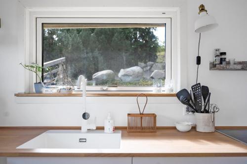 a kitchen with a sink and a window at Beautifully Situated Summer House With Sea View in Allinge