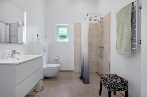 a white bathroom with a toilet and a shower at New And Cozy House By The Beach And Forest in Hornbæk