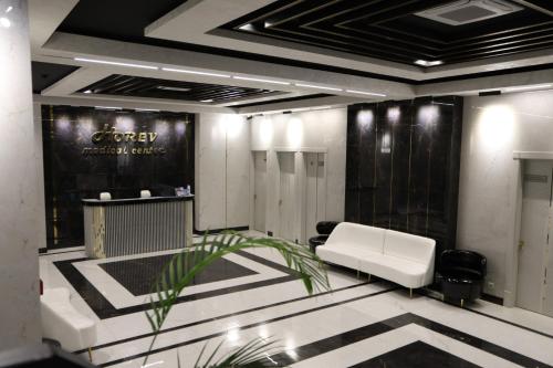 a dressing room with a white couch and a plant at Horev Medical Center in Tashkent