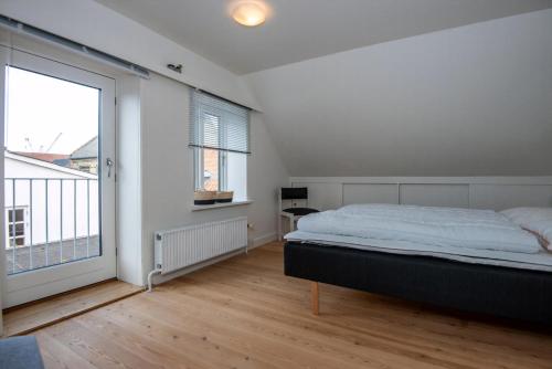 a bedroom with a bed and a large window at Cozy Central Located Townhouse In Nakskov in Nakskov