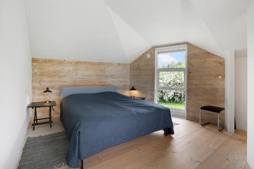 ein Schlafzimmer mit einem Bett und einem großen Fenster in der Unterkunft Malerisches Sommerhaus In Der Nähe Ruhiger, Plätschernder Wellen in Kirke-Hyllinge