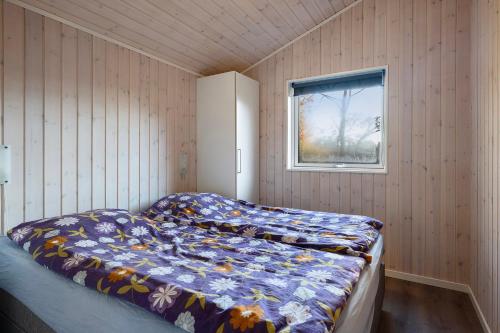 a bedroom with a bed in a room with a window at Charming Cottage In Fjellerup With Indoor Spa in Glesborg